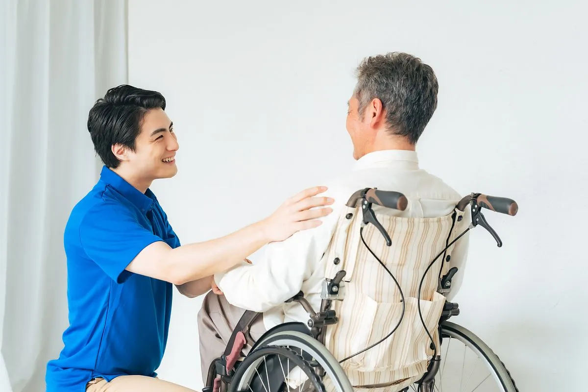 車椅子の男性と話しかける男性