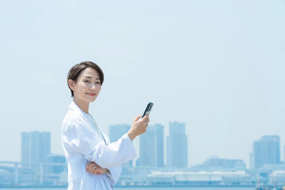スマホを持ちこちらを見る女性